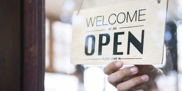 Young startup coffee cafe owener open and welcome customer.